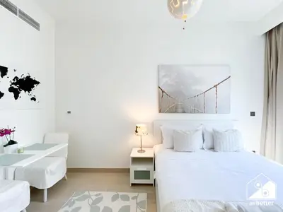 a bedroom with a white bed with a bridge painting on the wall at Bright City ST with Balcony l Pool, Gym & Wi-Fi in Dubai