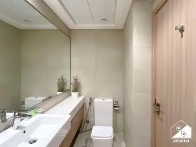 a bathroom with a toilet and a sink and a mirror at Bright City ST with Balcony l Pool, Gym & Wi-Fi in Dubai
