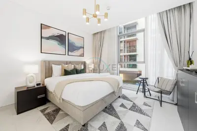 a bedroom with a large bed and a chandelier at Lagoon-Facing 1BR, Minutes from Downtown and Business Bay, Near Dubai Water Canal - District One Phase III Residences 18 by Deluxe Holiday Homes in Dubai