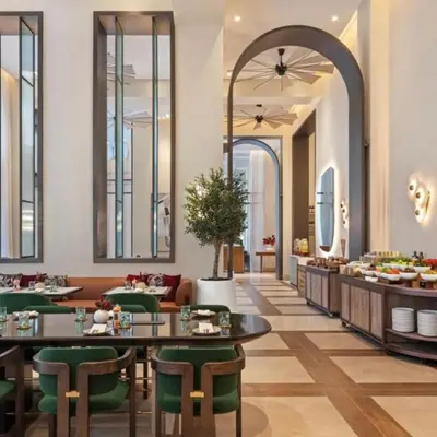 a dining room with tables and green chairs at Vida Residences - Luxury & Serenity - Creek Beach in Dubai