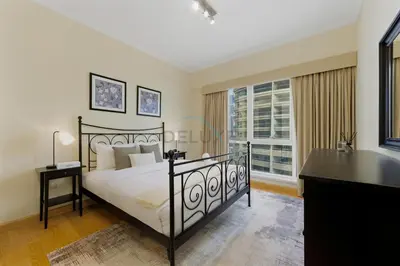 a bedroom with a bed and a desk and a window at Prime 2BR with Mesmerizing Canal Views, Stone Throw from Marina Mall and Metro, Minutes Walk to JBR Beach, Al Majara 1, Dubai Marina by Deluxe Holiday Homes in Dubai