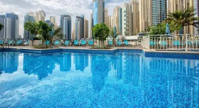 a large swimming pool in front of a city at Prime 2BR with Mesmerizing Canal Views, Stone Throw from Marina Mall and Metro, Minutes Walk to JBR Beach, Al Majara 1, Dubai Marina by Deluxe Holiday Homes in Dubai