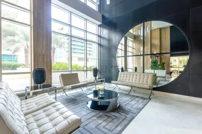 a lobby with white furniture and a round mirror at Prime 2BR with Mesmerizing Canal Views, Stone Throw from Marina Mall and Metro, Minutes Walk to JBR Beach, Al Majara 1, Dubai Marina by Deluxe Holiday Homes in Dubai
