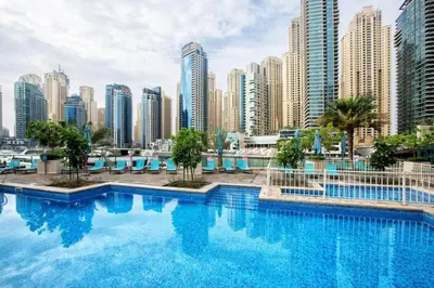 a large swimming pool in a city with tall buildings at Prime 2BR with Mesmerizing Canal Views, Stone Throw from Marina Mall and Metro, Minutes Walk to JBR Beach, Al Majara 1, Dubai Marina by Deluxe Holiday Homes in Dubai