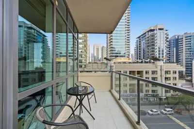 a balcony with a table and chairs and buildings at Prime 2BR with Mesmerizing Canal Views, Stone Throw from Marina Mall and Metro, Minutes Walk to JBR Beach, Al Majara 1, Dubai Marina by Deluxe Holiday Homes in Dubai