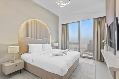 a bedroom with a large bed and a large window at Skyline Splendor 2bedroom with Burj Khalifa View in Dubai