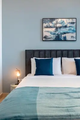 a bedroom with a large bed with blue and white pillows at Downtown views 1 Bedroom 5 PAX direct Dubai mall in Dubai