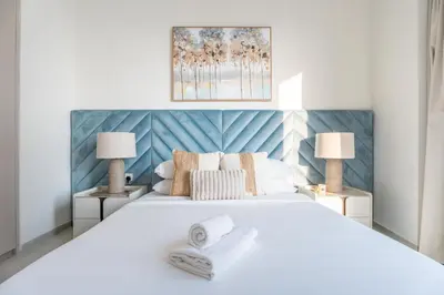 a bedroom with a large white bed with two lamps at GuestReady - 2BR l High-Rise Elegance in Dubai