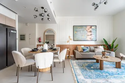 a living room with a table and chairs and a couch at GuestReady - 2BR l High-Rise Elegance in Dubai