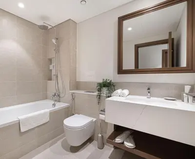 a bathroom with a toilet and a sink and a mirror at Beachfront 1BR with Private Beach Access in Dubai