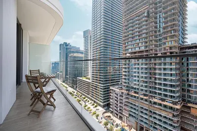 a balcony with a chair and a view of a city at Beachfront 1BR with Private Beach Access in Dubai