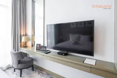 a living room with a large television on a wall at Modern Canal Studio near Downtown Dubai in Dubai