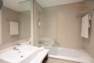 a white bathroom with a sink and a shower at Modern Canal Studio near Downtown Dubai in Dubai