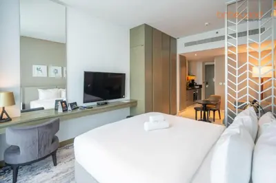 a hotel room with a bed and a flat screen tv at Modern Canal Studio near Downtown Dubai in Dubai
