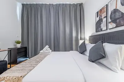 a bedroom with a large white bed and a window at Best Business Bay Location - Direct Views of Canal and Al Khail Racecourse - 1 min from Al Habtoor Palace in Dubai