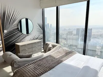 a bedroom with a bed and a large window at JBR Beach Access Luxury1BR Marina View High Floor in Dubai