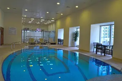 a large swimming pool in a hotel room at Private Room Steps from Marina Beach Dubai in Dubai
