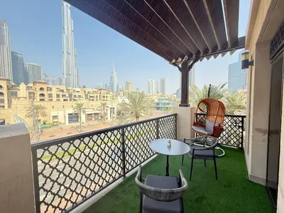 a balcony with a table and chairs and a view of the city at Downtown Burj Khalifa View One Bedroom Apartment in Dubai