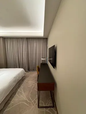 a bedroom with a bed and a desk with a television at 2 Bedroom Apartment in Address Opera Residences in Dubai