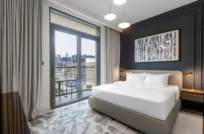 a bedroom with a large white bed and a large window at Bright 1BR Walk to Beach Marina Vista Dubai in Dubai