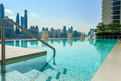 a swimming pool with a city skyline in the background at Bright 1BR Walk to Beach Marina Vista Dubai in Dubai