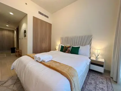 a bedroom with a large bed with towels on it at Kanisha Homes Azizi Riviera 48 by Vacay Xeal in Dubai