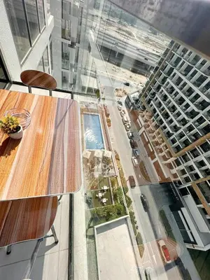 a glass table and chairs in front of a building at Kanisha Homes Azizi Riviera 48 by Vacay Xeal in Dubai