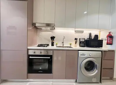 a kitchen with a sink and a washing machine at Kanisha Homes Azizi Riviera 48 by Vacay Xeal in Dubai