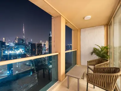a balcony with a view of the city at night at New Renovate Huge Flat w Canal & Burj Khalifa view in Dubai