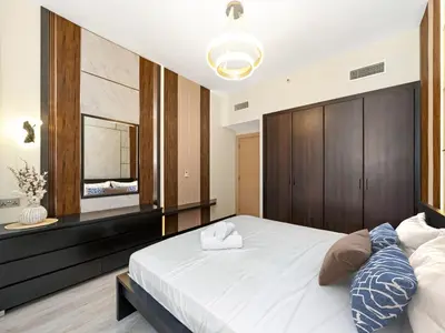 a bedroom with a large white bed and a mirror at New Renovate Huge Flat w Canal & Burj Khalifa view in Dubai