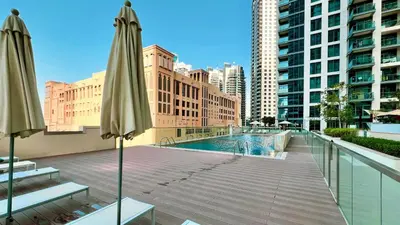 a balcony with a swimming pool and two umbrellas at Premium 3BR apartment with Burj Khalifa view, Downtown Dubai in Dubai
