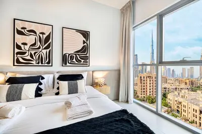 a bedroom with a large white bed and a large window at Premium 3BR apartment with Burj Khalifa view, Downtown Dubai in Dubai