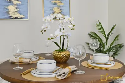 a dining room table with plates and wine glasses at 1BR Modern Escape in JVC Dubai in Dubai
