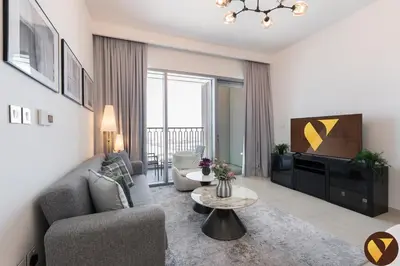 a living room with a couch and a tv at Vogue Downtown Views II with Direct Access to Dubai Mall Via a Climate Controlled Bridge, One Bedroom Apartment with Balcony and City View in Dubai