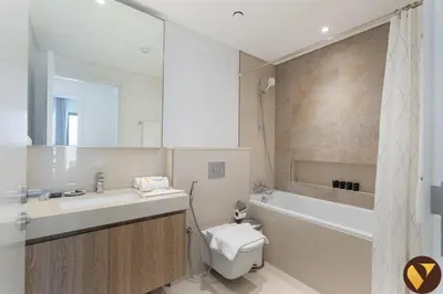 a bathroom with a sink and a toilet and a tub at Vogue Downtown Views II with Direct Access to Dubai Mall Via a Climate Controlled Bridge, One Bedroom Apartment with Balcony and City View in Dubai