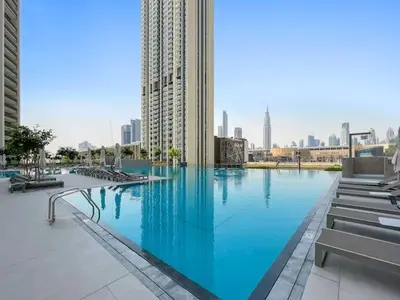 a large swimming pool in a city with buildings at Vogue Downtown Views II with Direct Access to Dubai Mall Via a Climate Controlled Bridge, One Bedroom Apartment with Balcony and City View in Dubai