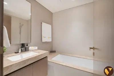 a bathroom with a large sink and a mirror at Vogue Emaar Beachfront Grand Bleu Designed by Elie Saab, near JBR and Palm Jumeirah, Two Bedroom Apartment with Balcony and Private Beach, Access to all Amenities in Dubai