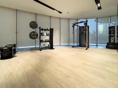 a large room with a gym with a wooden floor at 1BR in GRANDE with Balcony I Amazing INFINITY POOL I Steps to Dubai Mall & Fountain in Dubai