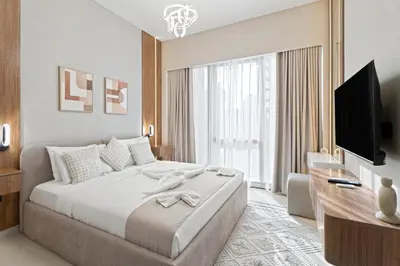 a hotel room with a large bed and a television at 1BR in GRANDE with Balcony I Amazing INFINITY POOL I Steps to Dubai Mall & Fountain in Dubai