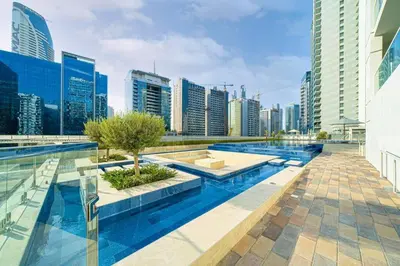 a pool in the middle of a city with tall buildings at Luxury 2BR with Dubai Canal View Near Burj Khalifa in Dubai