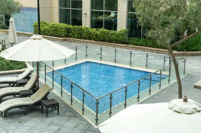 a swimming pool with an umbrella and a table and chairs at 1BR Apartment next to Dubai Mall & Burj Khalifa in Dubai