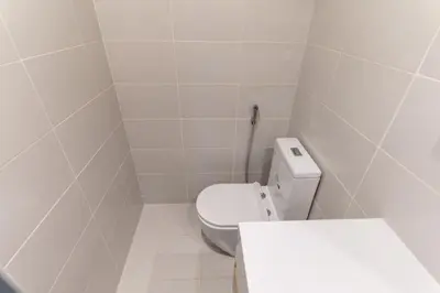 a white bathroom with a toilet and a sink at 1BR Apartment next to Dubai Mall & Burj Khalifa in Dubai