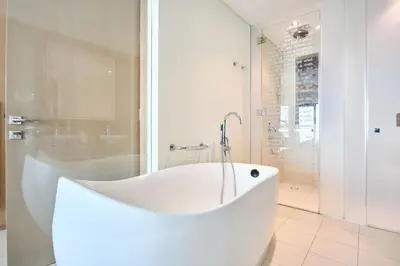 a white bath tub in a bathroom with a shower at Burj Khalifa View High-Floor Upgraded 3Bed Apt in Dubai