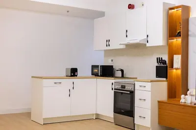 a kitchen with white cabinets and a stove top oven at Lux 3 Bedroom apartment in Marina DEC 1103 in Dubai