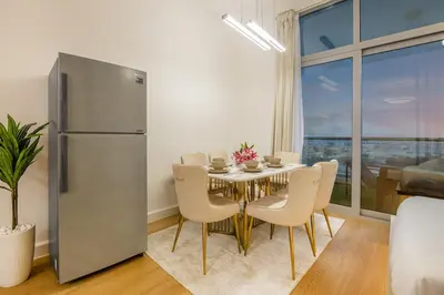 a dining room with a table and a refrigerator at Lux 3 Bedroom apartment in Marina DEC 1103 in Dubai