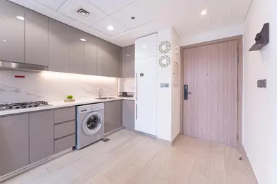 a kitchen with a washing machine and a door at HAVN - Spacious 1 bedroom in Azizi Riviera, Meydan in Dubai