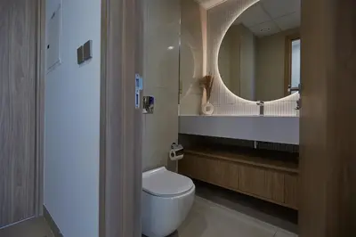 a bathroom with a toilet and a large mirror at Casa Haven Retreat in Dubai