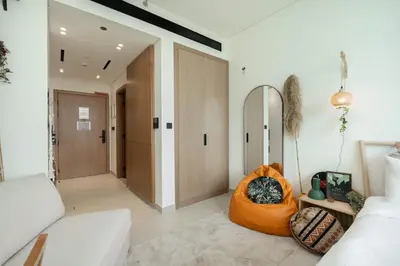 a living room with a couch and a mirror at StayShort - Stylish Boho Studio in JVC Dubai Staycation Sleeps 2 in Dubai