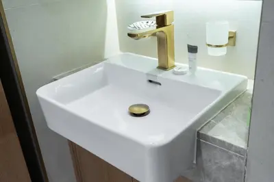 a white sink with a gold faucet in a bathroom at StayShort - Stylish Boho Studio in JVC Dubai Staycation Sleeps 2 in Dubai