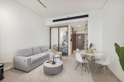 a living room with a couch and a table at Studio Apartments with Private Jacuzzi - Spa - Cold Plunge - Gym in Business Bay in Dubai